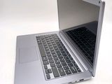 a silver laptop computer sitting on top of a white table