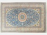 un tapis bleu orné d’un motif en médaillon sur fond blanc