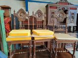 four wooden chairs with yellow cushions on them in a room