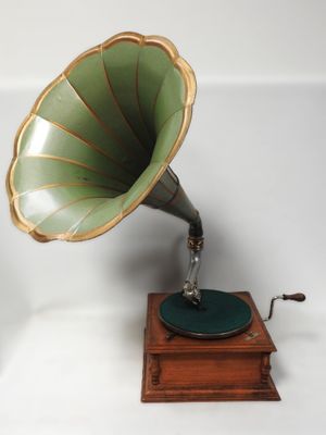 un Phonom vert et doré posé sur un socle en bois