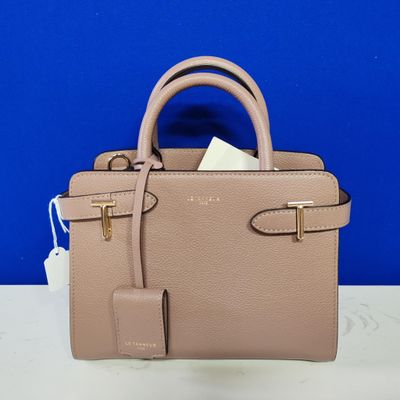 a small beige purse with a tag on it