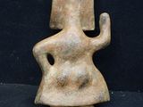 an old figurine of a woman with a hat on her head