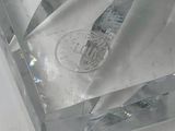 a clear crystal block with a coin on top of it