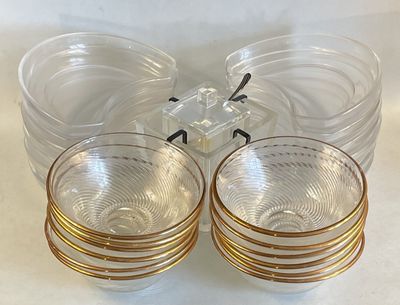 four clear glasses with gold rims sitting on a table