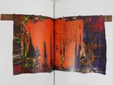 an open book with a picture of a city on it