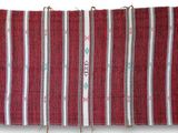 a close up of a red and white striped towel hanging on a wall
