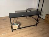 a black desk with a laptop on it in a room