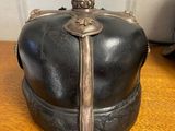 a metal crown on a wooden table next to a bag