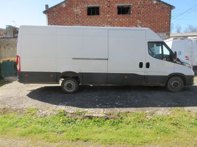 une camionnette blanche garée devant un immeuble en briques