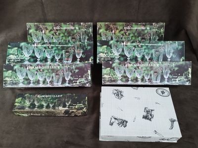 Plusieurs cartons de verres à vin sont posés sur une table