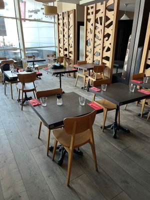 tables and chairs in a restaurant with a large window in the background