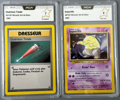 two pokemon cards are shown in plastic cases on a table