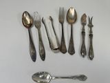 a lot of silver spoons and forks on the table