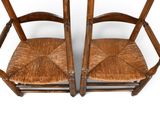 pair of wooden chairs with wicker seats on a white background