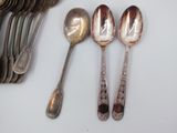 a lot of silver spoons and spoons on the table