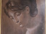 painting of a woman ' s face in a gold frame on a wall