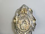 a silver plate with a picture of the virgin of guadalupe on it