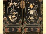 une image représentant un meuble noir orné de fleurs et d'oiseaux peints