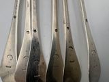 four silver spoons are lined up on top of each other