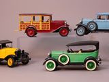 three different model cars on display on a clear stand