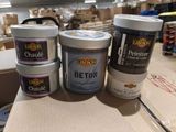 trois pots de peinture posés sur une boîte en carton