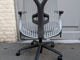 a black and white office chair with wheels on the sidewalk