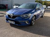 une voiture bleue garée dans un parking à côté d'un bâtiment