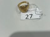 une bague en or posée sur une table blanche