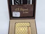 une photo d'un briquet en or dans une boîte avec un porte-cartes