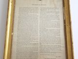 un vieux document encadré sur lequel figure la photo d'un homme