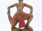 statue of a woman sitting on a stool with her legs crossed