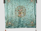 a green and pink floral tapestry hanging on a wall