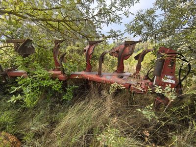 a red tractor that is sitting in the grass