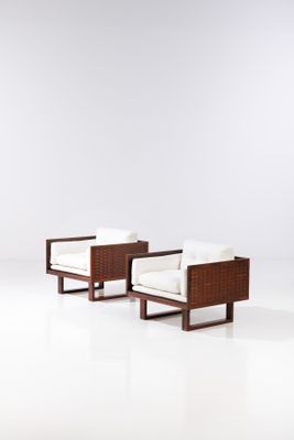 a pair of lounge chairs in the style of person