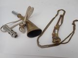 a brass bell and a chain on a white surface