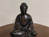 une statue de Bouddha assis sur une table en bois