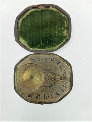 une boîte ouverte contenant une horloge, posée sur une surface blanche