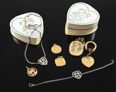 two heart shaped jewelry boxes and a chain on a black surface