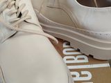 pair of white shoes sitting on top of a box on top of a table