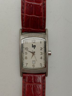 une image d'un gros plan d'une montre-bracelet sur une surface blanche