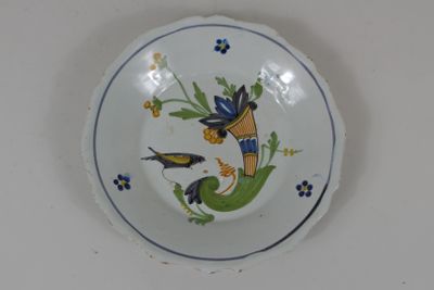 une assiette sur laquelle sont représentés deux oiseaux, posée sur une table