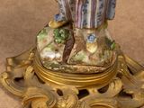 a figurine of a woman holding a bird on a stand