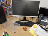 un bureau sur lequel se trouvent un ordinateur, un clavier, un téléphone et d'autres objets