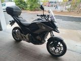 une moto noire garée sur un parking à côté d'un immeuble