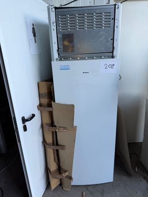 a white refrigerator and a stack of boxes in a room