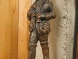 a statue of a man that is standing on a shelf