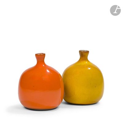 deux vases orange et jaune posés l'un à côté de l'autre sur une surface blanche