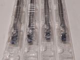 six types différents de brosses à dents dans des étuis en plastique transparent posés sur une table