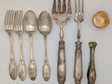 a lot of silver spoons and forks on the table
