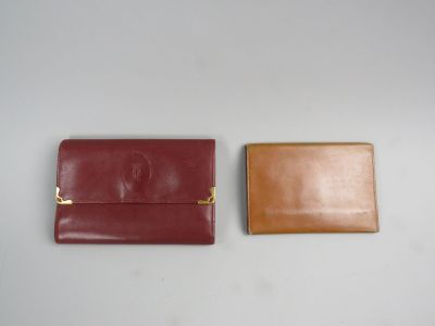 deux portefeuilles en cuir posés l'un à côté de l'autre sur une surface blanche